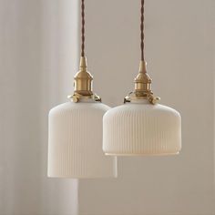 two white lamps hanging from a ceiling in a room