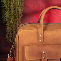 a brown leather briefcase sitting on top of a wooden table