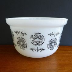 a white bowl sitting on top of a wooden table