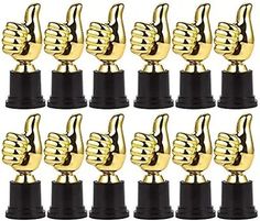 twelve gold trophy trophies with thumbs up on each one and black pedestals in the middle