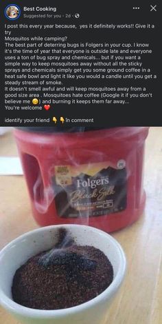 a white bowl filled with coffee sitting on top of a wooden table next to a red container