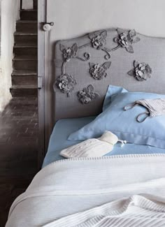 an old photo of a bed with flowers on the headboard and pillows in black and white