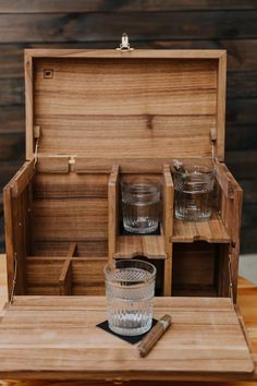 an empty wooden box with two shot glasses in it