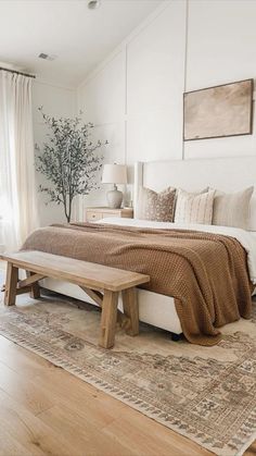 a bedroom with a bed, bench and window in the corner that overlooks an outdoor deck