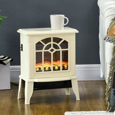 a white stove sitting on top of a hard wood floor next to a plant in a living room