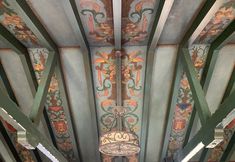 the ceiling is decorated with intricate designs and colors, including paint on wood paneling