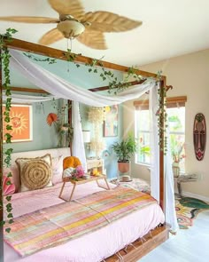 a canopy bed with white drapes on top of it in a room filled with potted plants