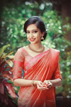 a woman in an orange sari is smiling