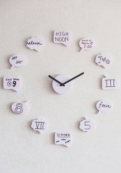 a clock made out of white paper with numbers and speech bubbles on the face that read high noon