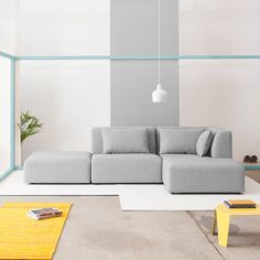 a large gray couch sitting in a living room next to a yellow rug on the floor