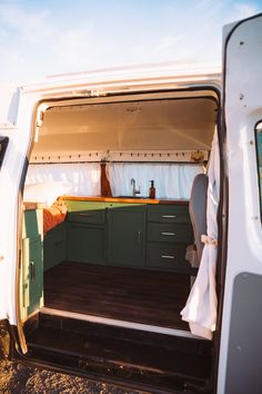 the interior of a van with its doors open and wood flooring in front of it