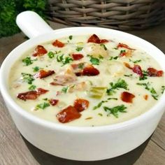 a white bowl filled with soup sitting on top of a wooden table