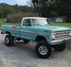 a blue truck parked on top of a gravel road