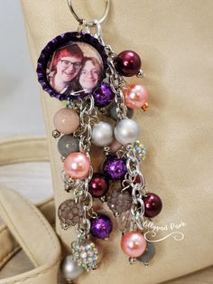 a keychain with an image of two people and pearls hanging from it's side