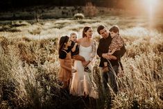 a group of people standing around each other in a field with the sun shining on them