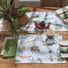 a table set with place mats, napkins and cups