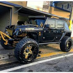 a black and gold jeep parked in front of a building