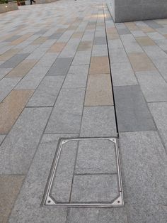 a metal grate sitting on the ground in front of a building