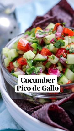 a bowl filled with cucumber, red onion and cilantro salsa next to tortilla chips