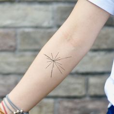 a woman's arm with a small star tattoo on the left side of her arm