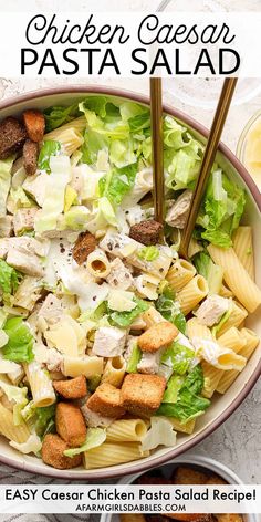 chicken caesar pasta salad in a bowl with two serving spoons on the side and text overlay that reads easy cheesy chicken pasta salad