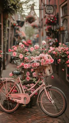 a pink bicycle parked on the side of a street with flowers growing out of it