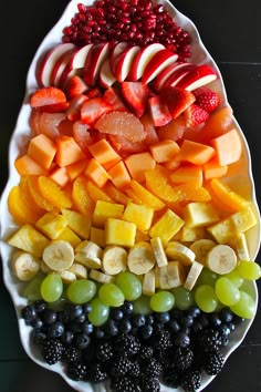 a platter filled with sliced fruit and berries