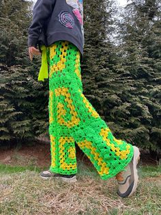 a person wearing green and yellow crocheted pants