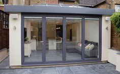 an outdoor living room with sliding glass doors on the outside and patio area in front