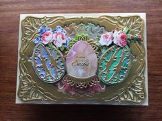 a close up of a card on a wooden surface with flowers and leaves in it