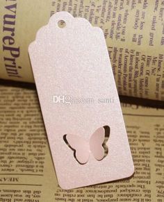 a pink butterfly shaped tag sitting on top of an open book