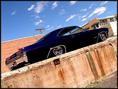 an old black car parked on the side of a road