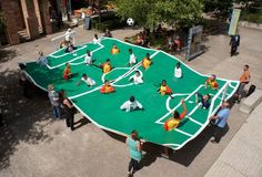 a group of people standing around a giant soccer field