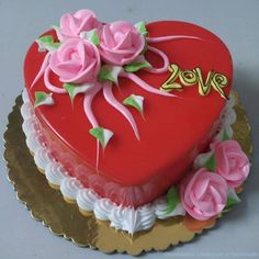 a heart shaped cake with pink roses on top