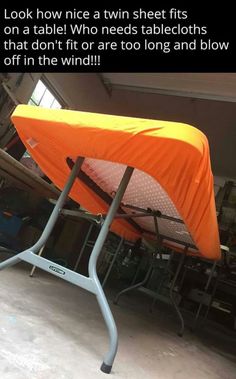 an orange table cover sitting on top of a metal stand