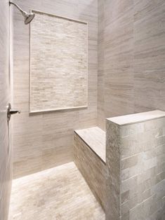 a white tiled bathroom with a bench and shower