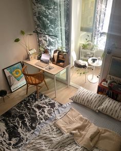 a bed room with a neatly made bed next to a desk and chair in front of a window