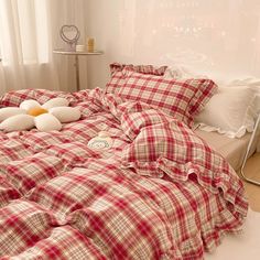 a bed with red and white checkered comforter, pillows and two teddy bears on it