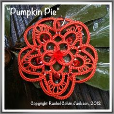 a red brooch with an intricate design on it's center and the words pumpkin pie