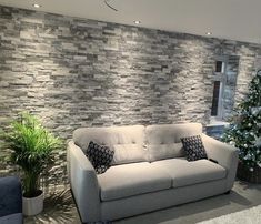 a living room with a couch and a christmas tree in the corner next to it