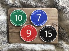 four numbered stickers on top of a wooden plaque with the number nine and seven