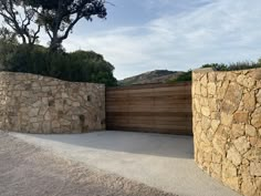 two stone walls next to each other near a tree