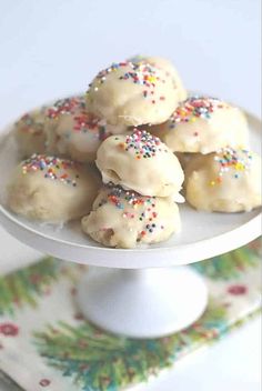 a white plate topped with donuts covered in sprinkles on top of a table