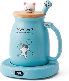 a blue ceramic coffee mug with a cat on it's lid and the words enjoy joy