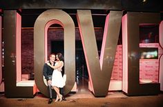 a man and woman standing in front of the word love