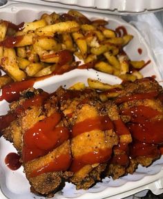 two trays filled with chicken, fries and ketchup on top of each other