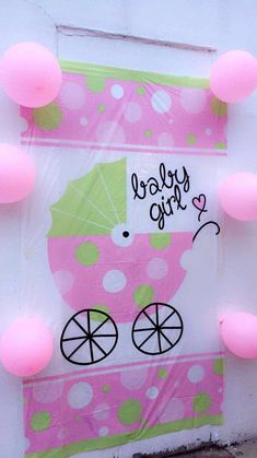 a pink and green baby carriage with balloons around it