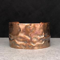 This double-gauge copper cuff is softly textured with flowing ribbon lines and shallow crevices.  Comfortable to wear and easy to adjust.  Creating this involved several metal working techniques: air chasing, riveting, and soldering.   It will accommodate small-medium sized wrists. DETAILS- -Circumference: 6 & 1/2 inches with 1 & 1/4 inch opening  -Width 1 & ½ inches All my pieces are handmade using eco-friendly metal (recycled, reclaimed, or upcycled), fair trade beads and stones, genuine sea glass  and fossils I've personally collected, and other treasures I've been lucky enough to find.  When creating jewelry, my first question is: how can the metal best complement the centerpiece? I use a variety of smithing techniques such as wire working, sweat soldering, hand tooling, chain forging, Adjustable Hammered Copper Cuff Bracelet, Adjustable Hammered Bronze Cuff Bracelet, Sweat Soldering, Great White Shark Teeth, Williamsburg Va, Carnelian Ring, Copper Cuff, Creating Jewelry, Trade Beads