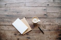 an open book with a cappuccino on it next to a cup of coffee