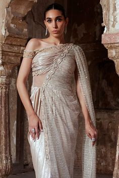 Champagne gold shimmer one-shoulder saree gown with scallop bead and pearl embroidery. - Aza Fashions Hand Embellished Floor-length Pre-draped Saree For Wedding, Glamorous Dresses With Zari Work And Traditional Drape, Glamorous Embellished Saree Gown, Glamorous Pre-draped Saree With Cape Sleeves For Reception, Glamorous Pre-draped Saree With Cape Sleeves, Elegant Pre-draped Saree With Pearl Embroidery For Evening, Glamorous Draped Dress With Zari Work, Evening Saree With Pearl Embroidery, Elegant Pre-draped Saree With Pearl Embroidery For Party